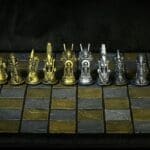 Ornate gold and silver chess pieces on board.