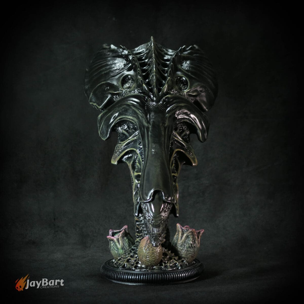 Intricate dark alien sculpture with floral base.