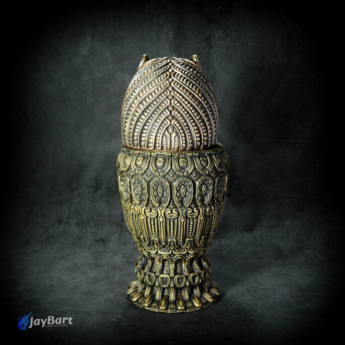Intricately designed ornate metal vessel on dark background.