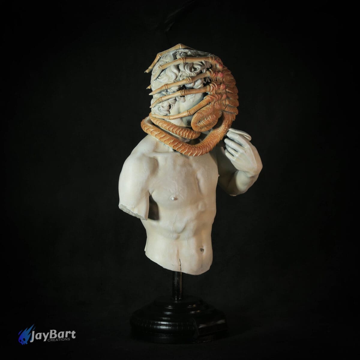 Torso statue with creature wrapped around head.