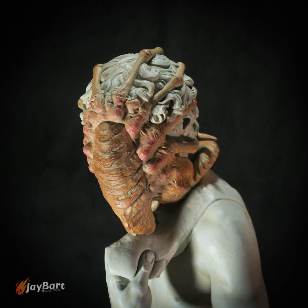 Sculpture of person with insect-like head features.