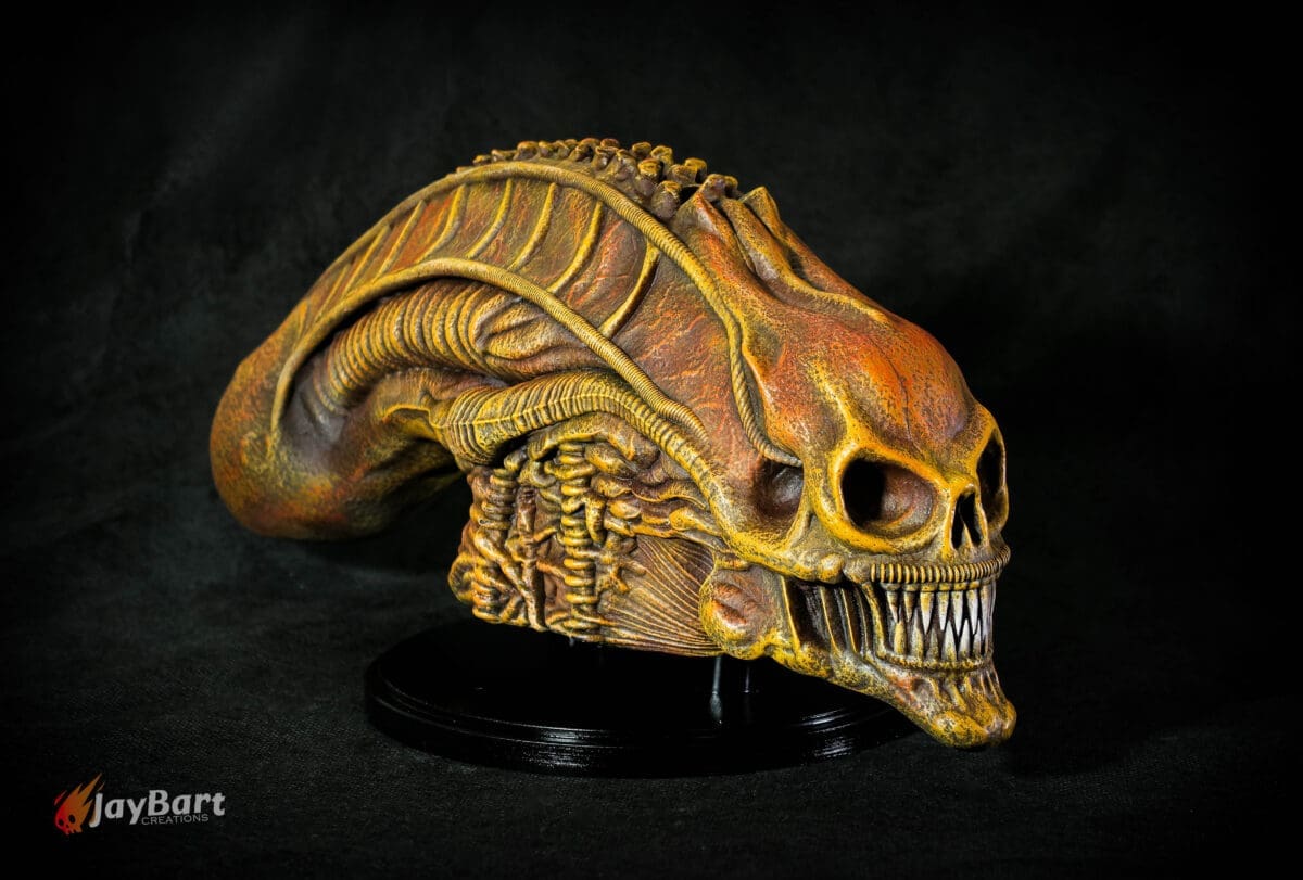 Detailed alien skull sculpture on black background.