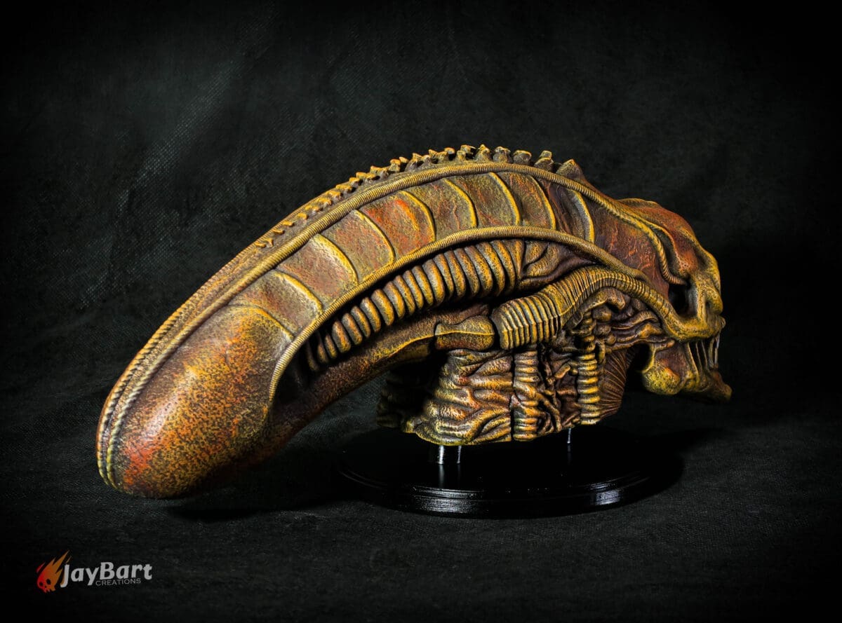Detailed alien creature sculpture on black background.