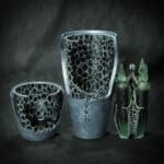 Three artistic, metallic vases with intricate designs.