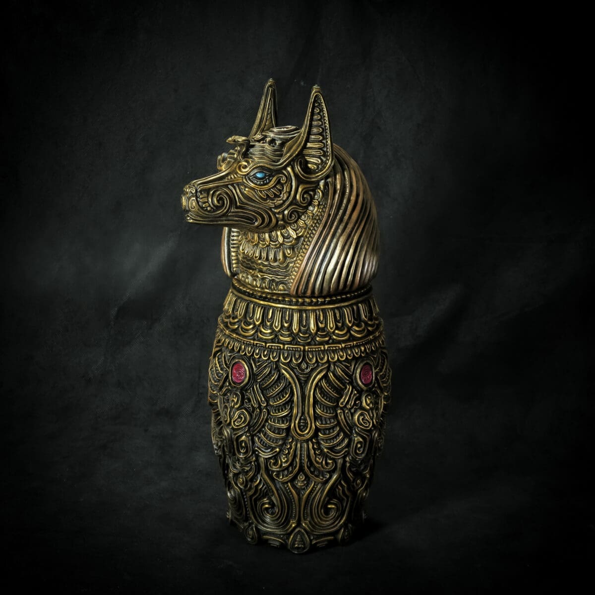 Intricate brass Anubis statue with detailed patterns.