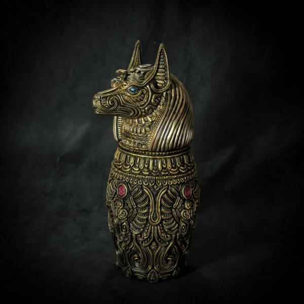Intricate brass Anubis statue with detailed patterns.