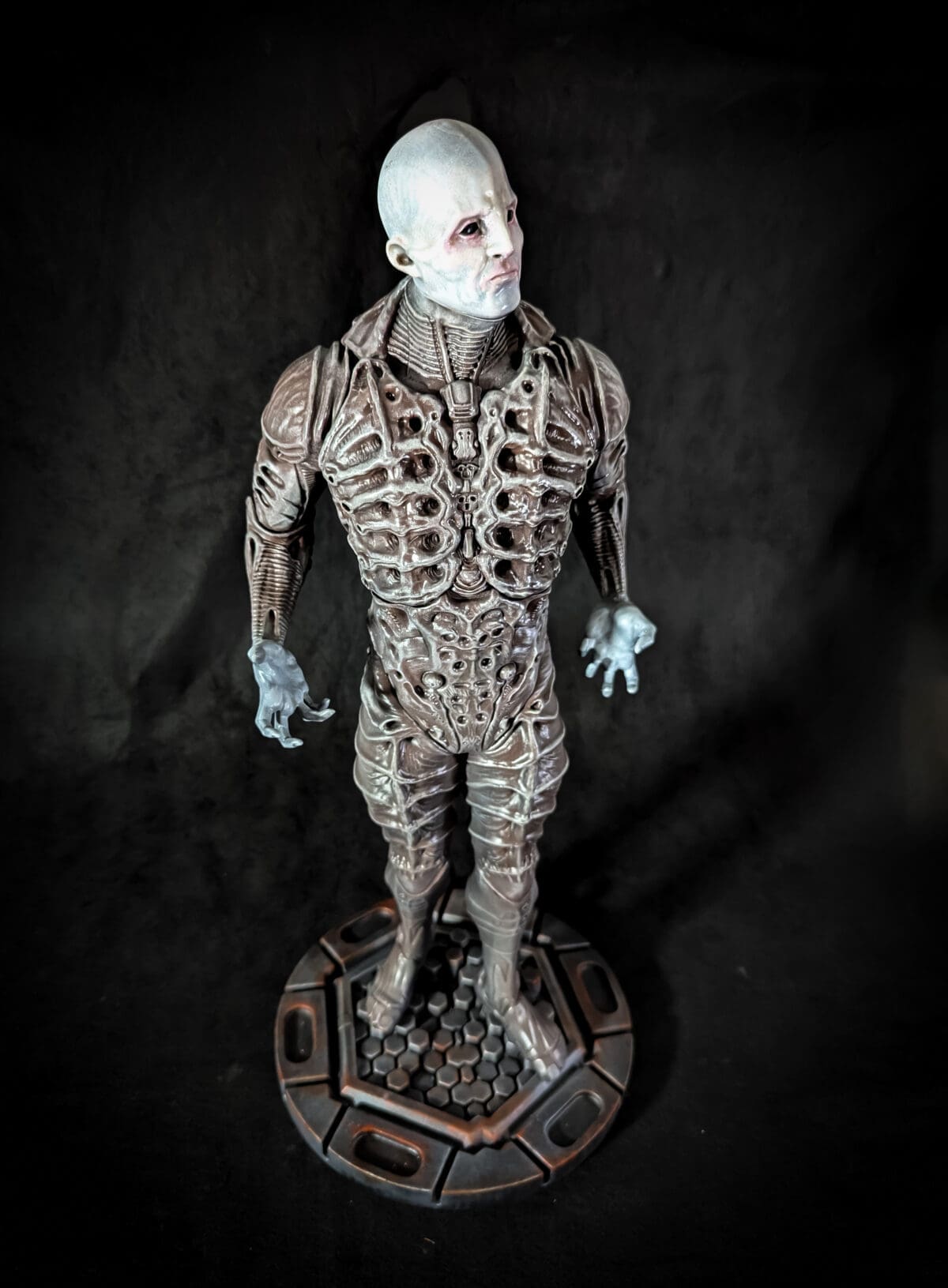 Sculpture of humanoid alien with intricate design.