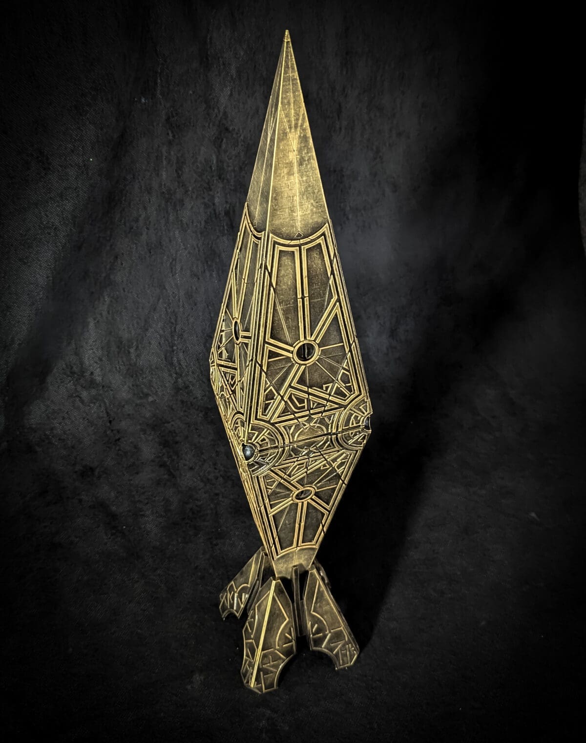 Intricate brass geometric sculpture on black background