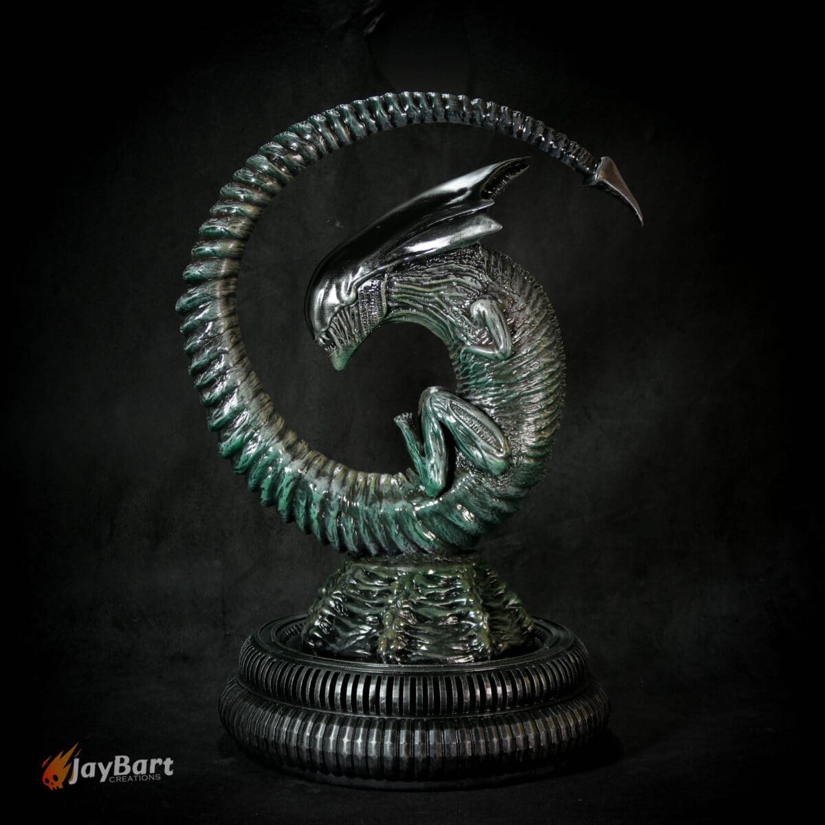 Intricate alien sculpture with spiral design on stand.