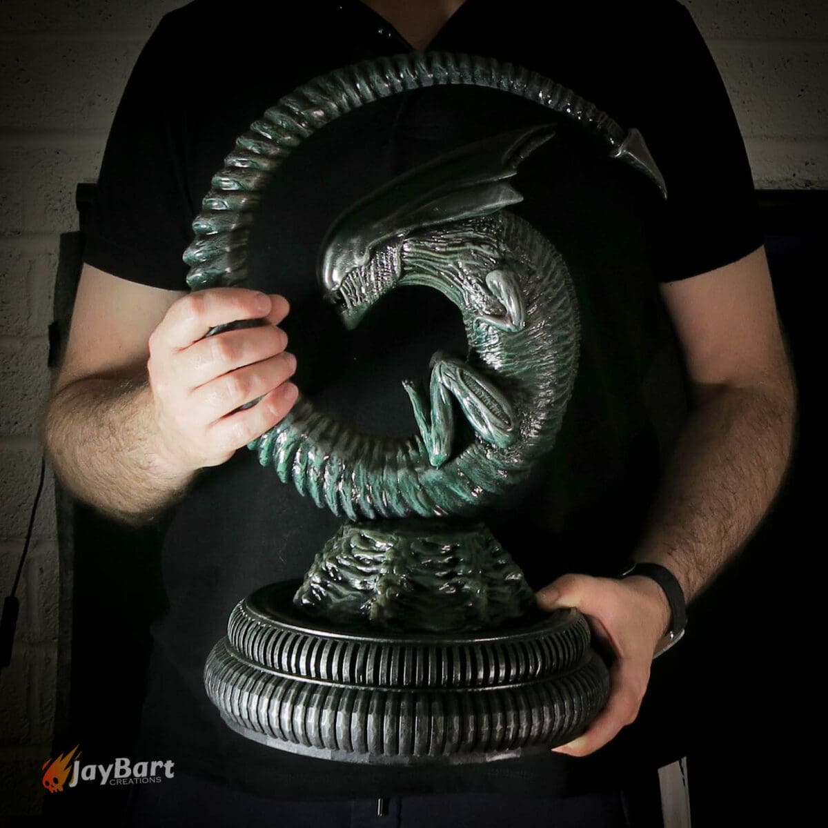 Person holding a detailed alien sculpture