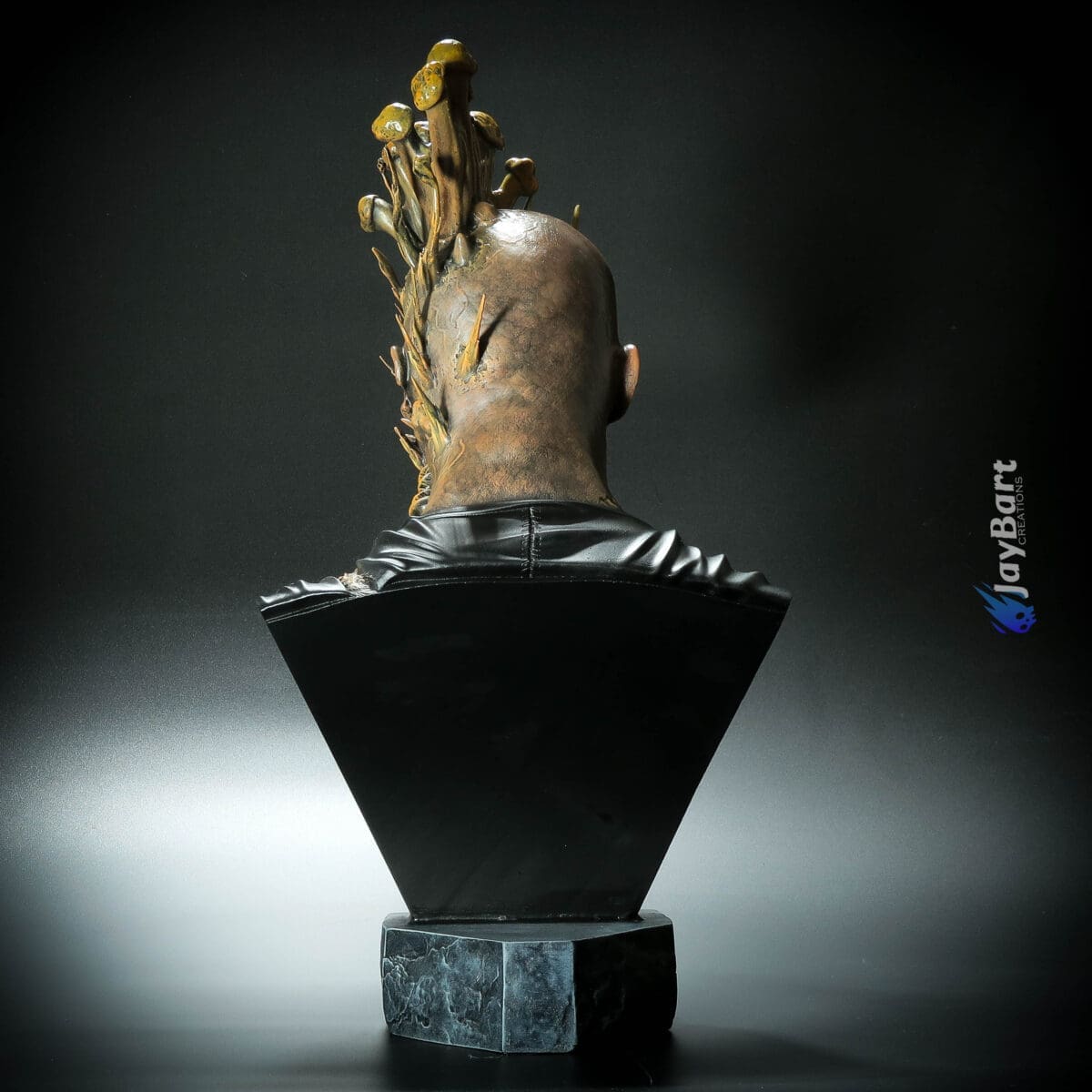 Back view of sculpture with mushrooms growing on head.