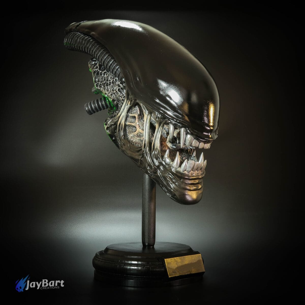 Alien head sculpture on display stand.