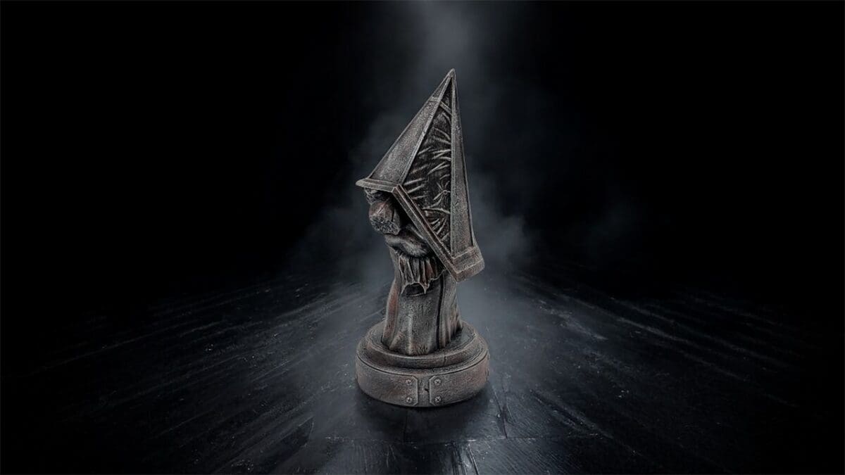 Dark, mysterious hooded figure statue on black background.